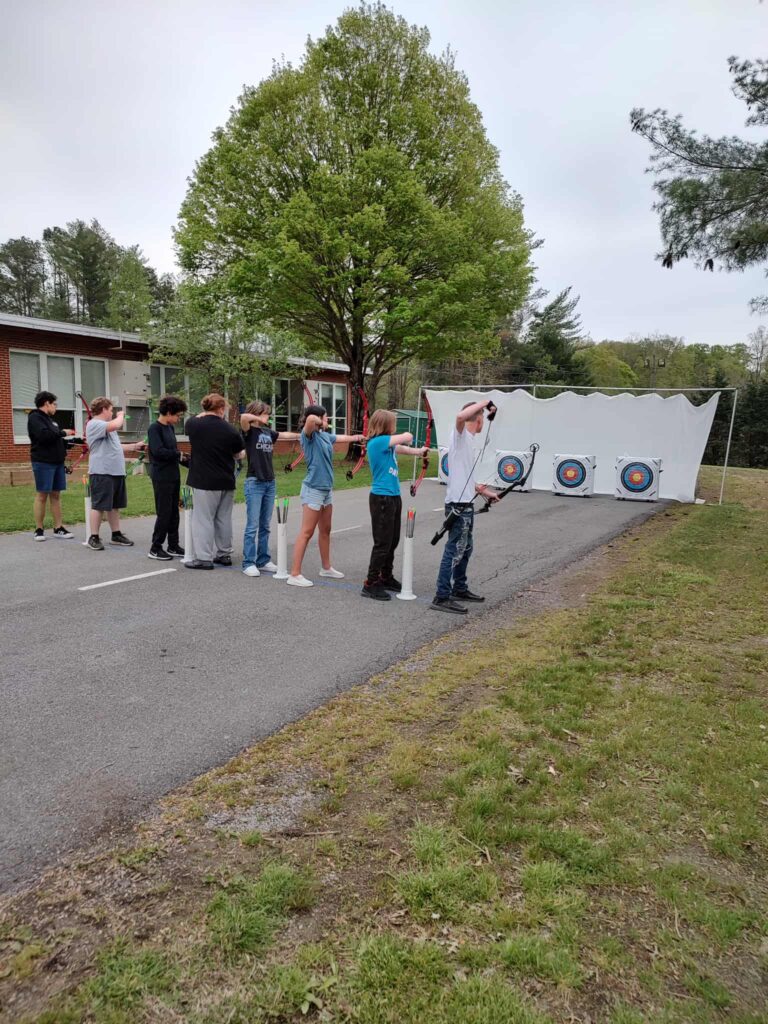 Archery students shooting shooting bows at targets